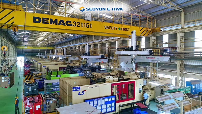 A modern manufacturing facility with overhead cranes and industrial equipment, highlighting the production capabilities of Seoyon E-HWA.